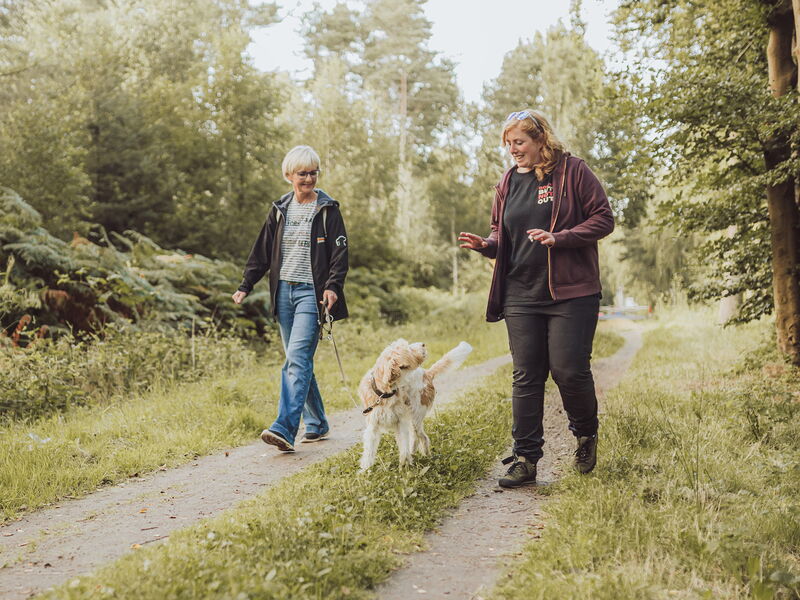 Hundetrainerin Sophia erklärt etwas einer Frau mit angeleintem Hund