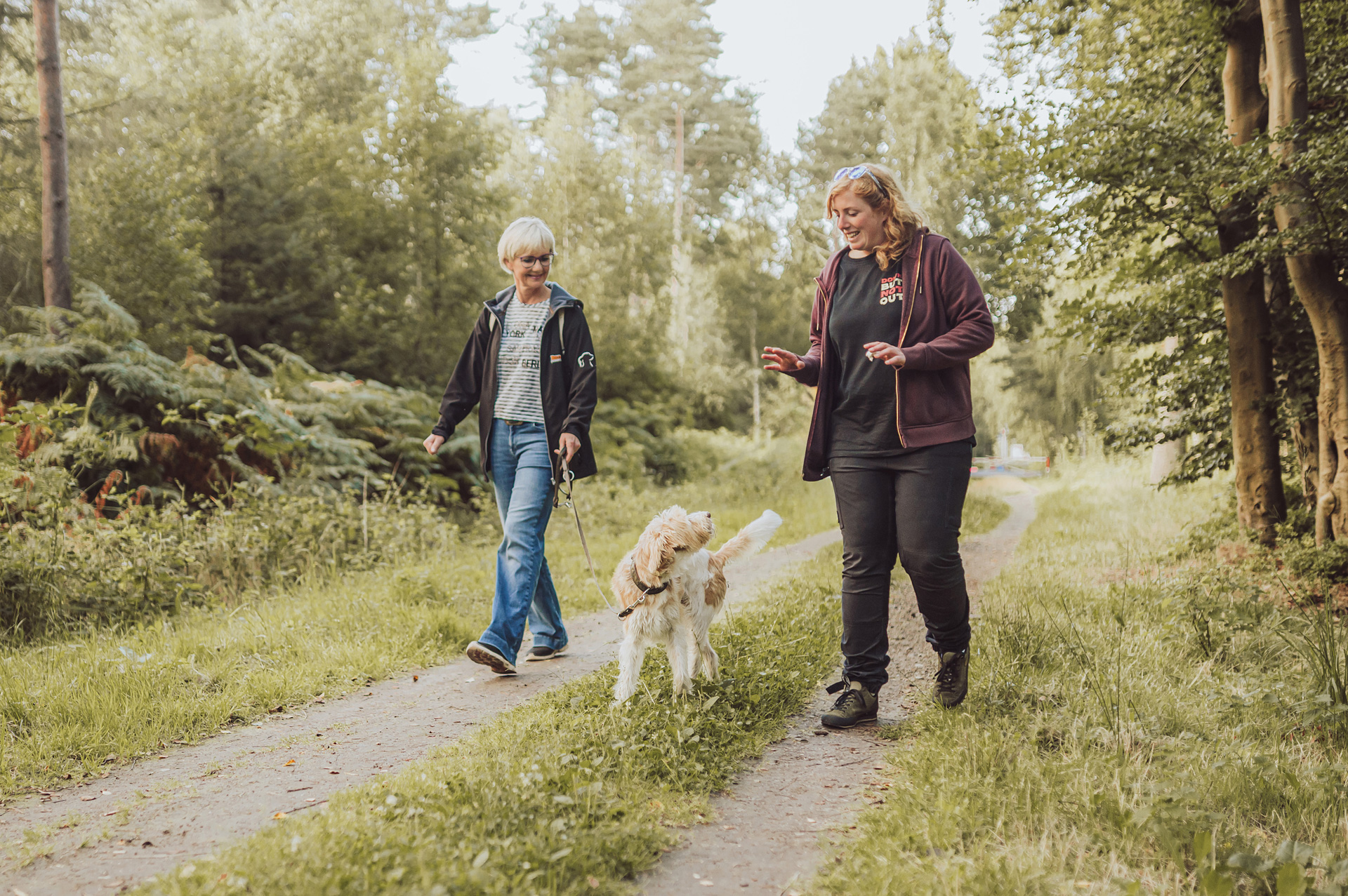 Hundetrainerin Sophia erklärt etwas einer Frau mit angeleintem Hund